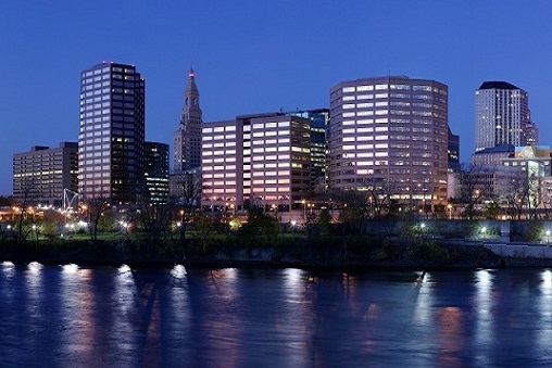 The Connecticut River slides by the attractive downtown core for Hartford.  This distinctive state capital hosts the industrial headquarters of many insurance companies, as well as high technology corporations.  The Traveler's Tower is still the centerpiece of this New England skyline.